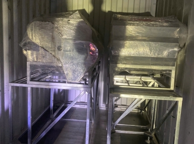 Packing a container of processing machinery for shipment to Tanzania.